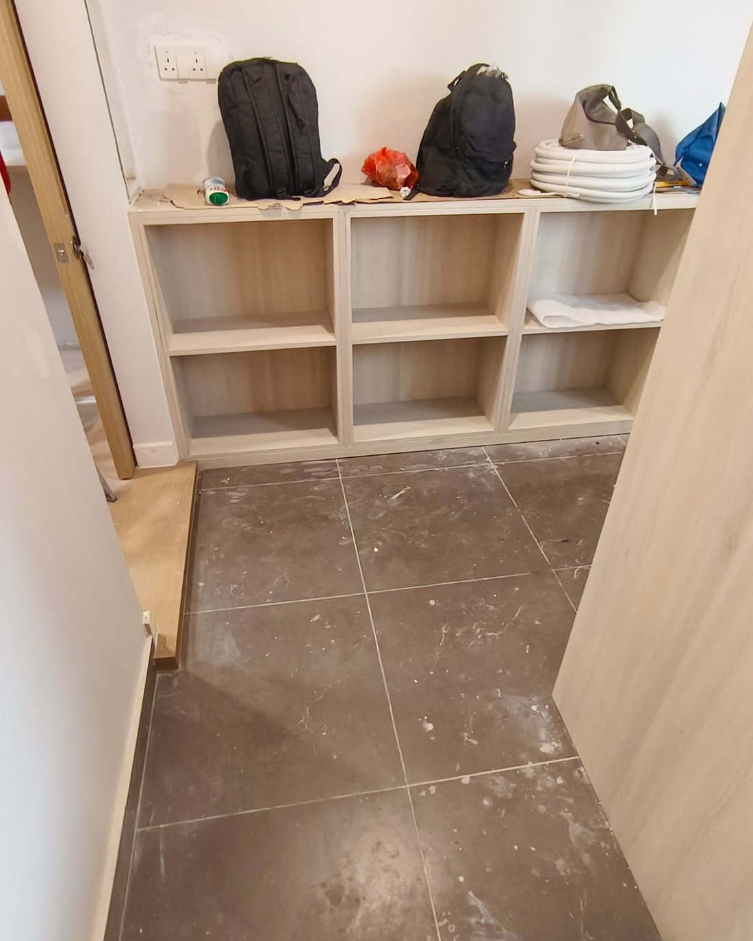 Built-in display nook before cleaning with stained floor and dust