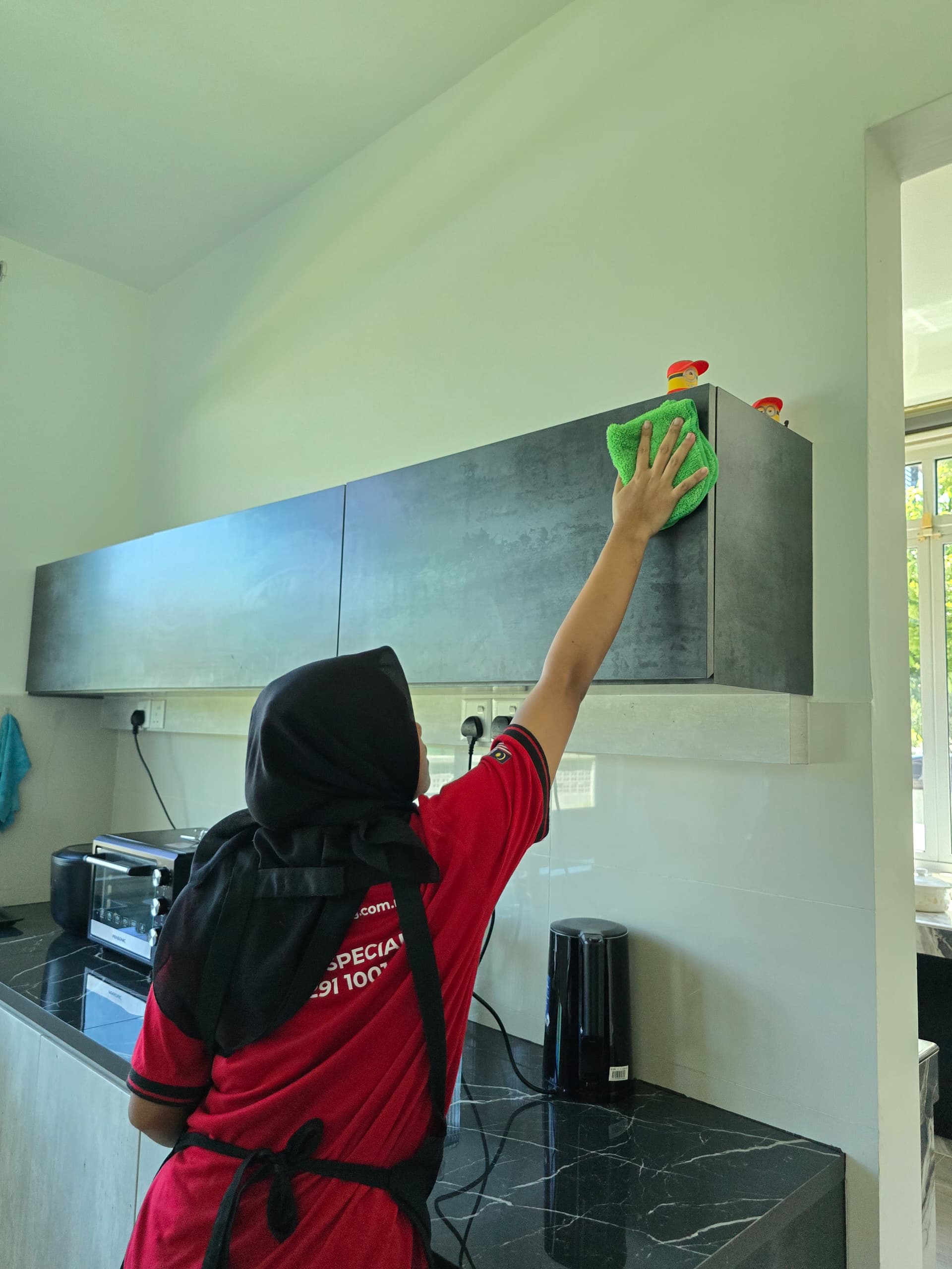 Ultra Cleaning specialist wiping down kitchen cabinets